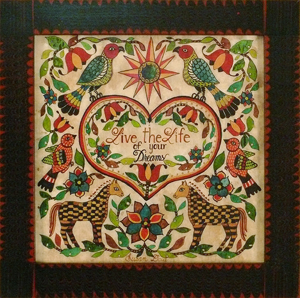 A colorful art and craft paper with a fraktur print design, featuring birds, flowers, and a heart-shaped center with the text 'Live the Life of Your Dreams'.