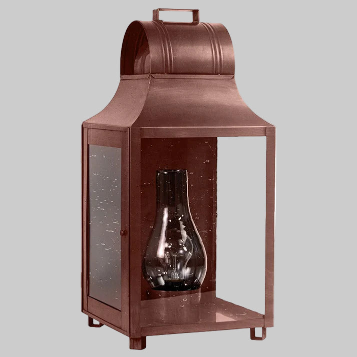 Bronze-colored lantern with a glass insert on a white background