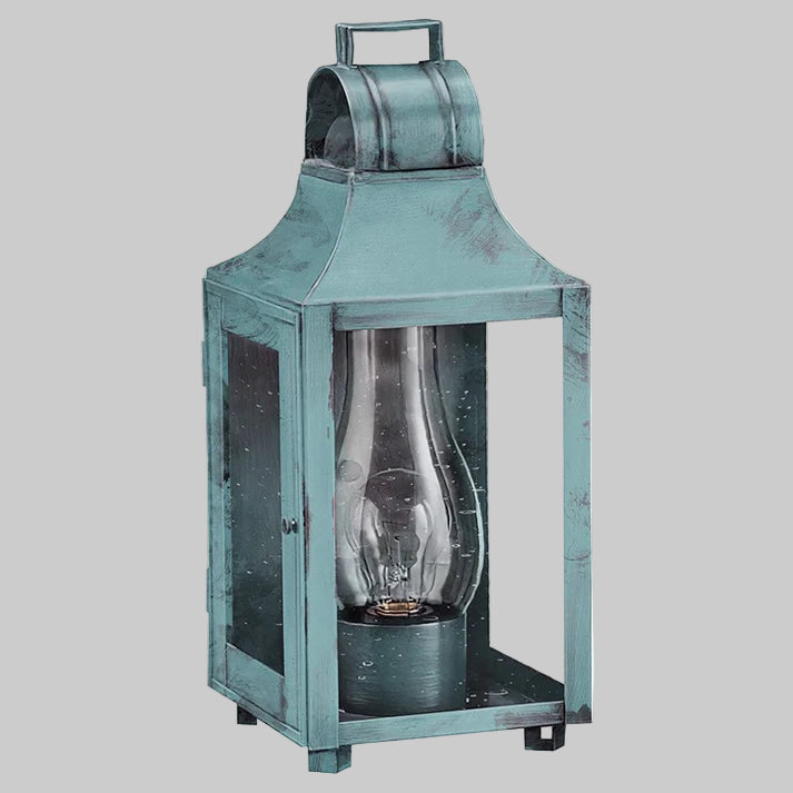 Vintage-style teal lantern with a clear glass cover on a gray background