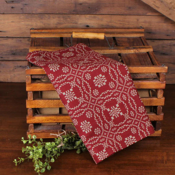 Lover's knot barn red towel on top of wooden crate with greenery