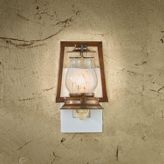 A mounted Lumberton night light with a clear glass globe and a brown wooden frame, illuminated and mounted on a wall.