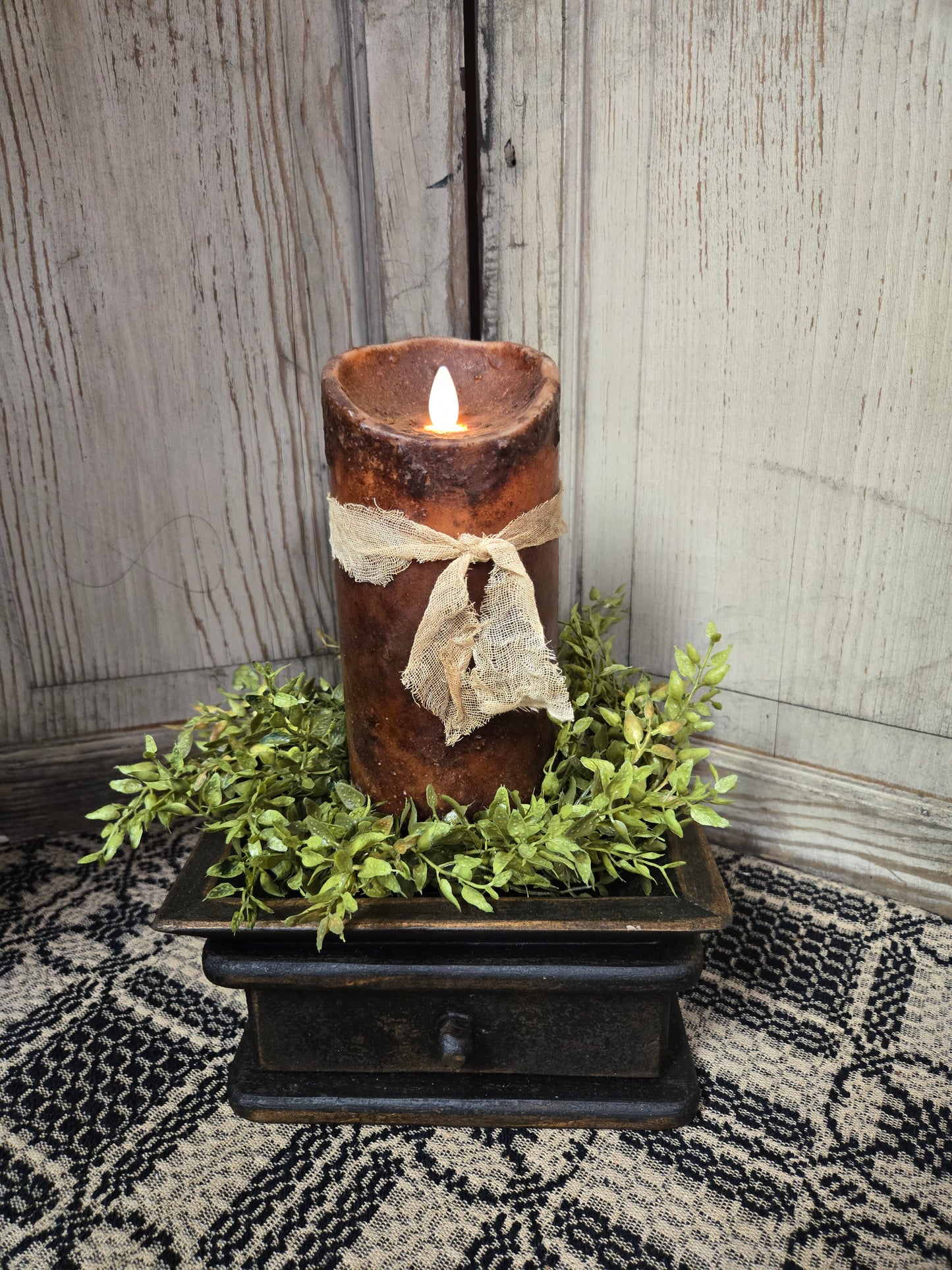 Realistic looking moving flame 7 inch dark brown pillar candle on black holder with drawer.