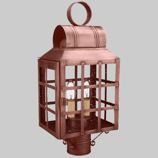 Copper outdoor lantern with two visible light bulbs on a gray background