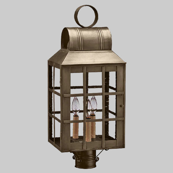 Bronze outdoor lantern with glass panels on a gray background