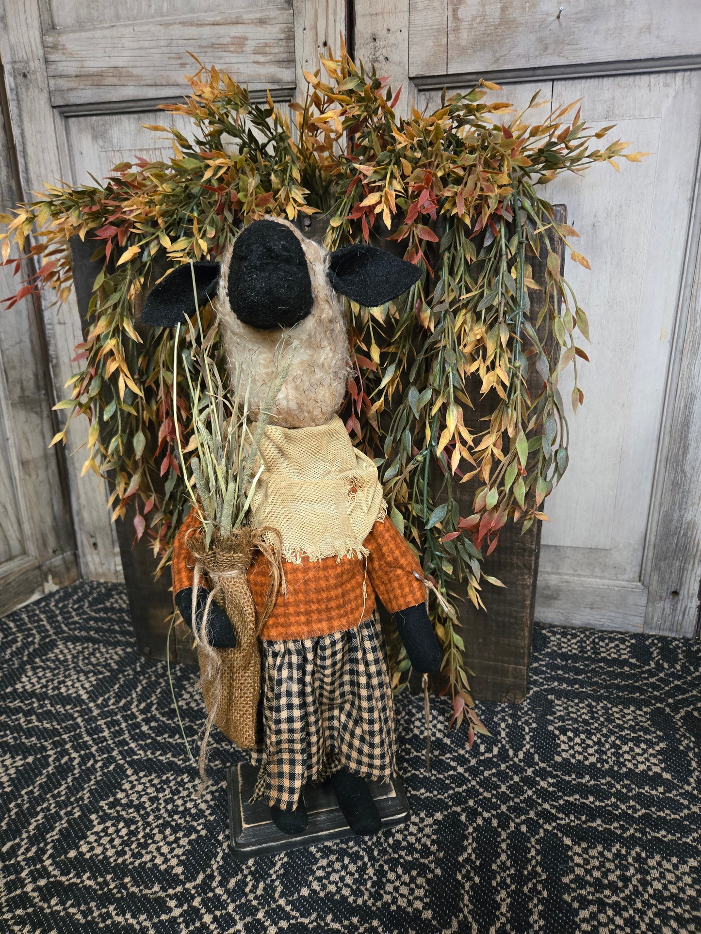 Decorative foliage with a sheep figurine on a textured surface
