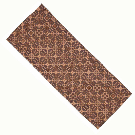 A jacquard table runner with a geometric pattern in black and tan colors.