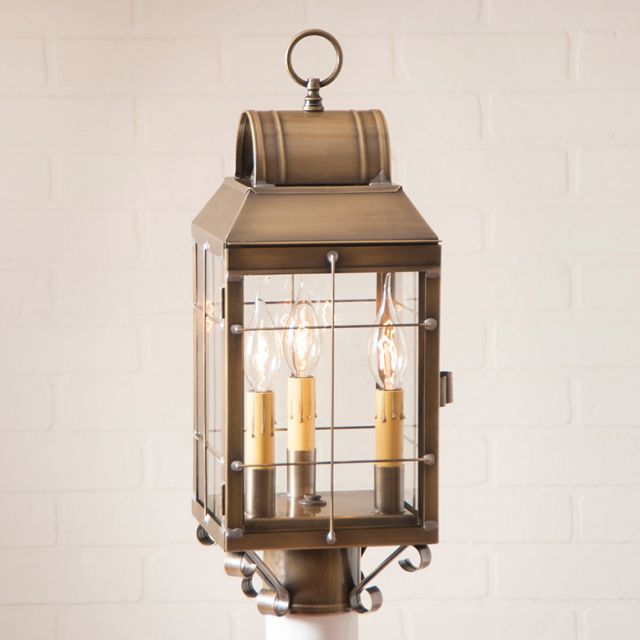 Decorative brass lantern with glass panels on a white background