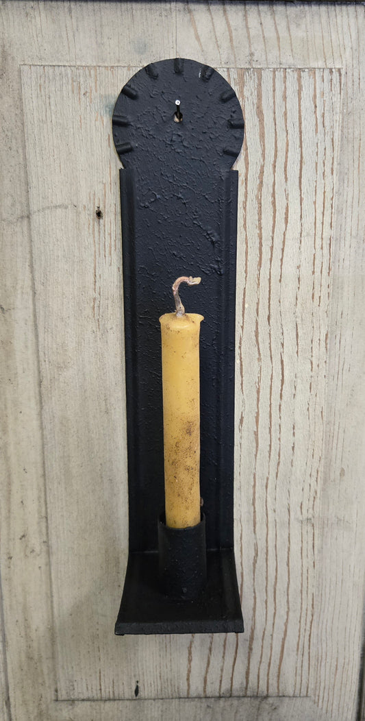 A black metal candle sconce with a textured finish, designed to hold a taper candle, mounted on a wall.