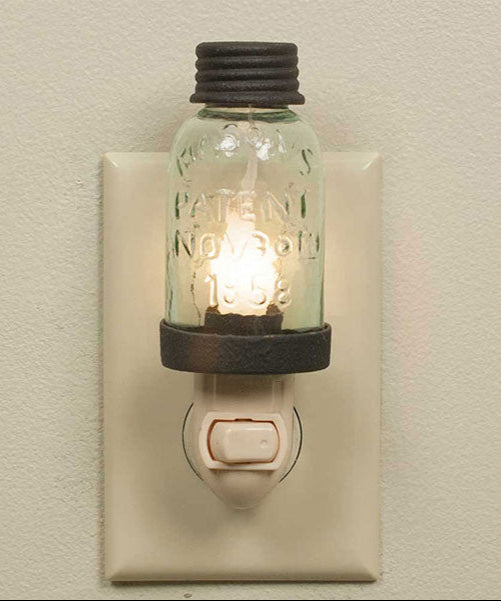 Small night light with a miniature mason jar design plugged into a wall outlet