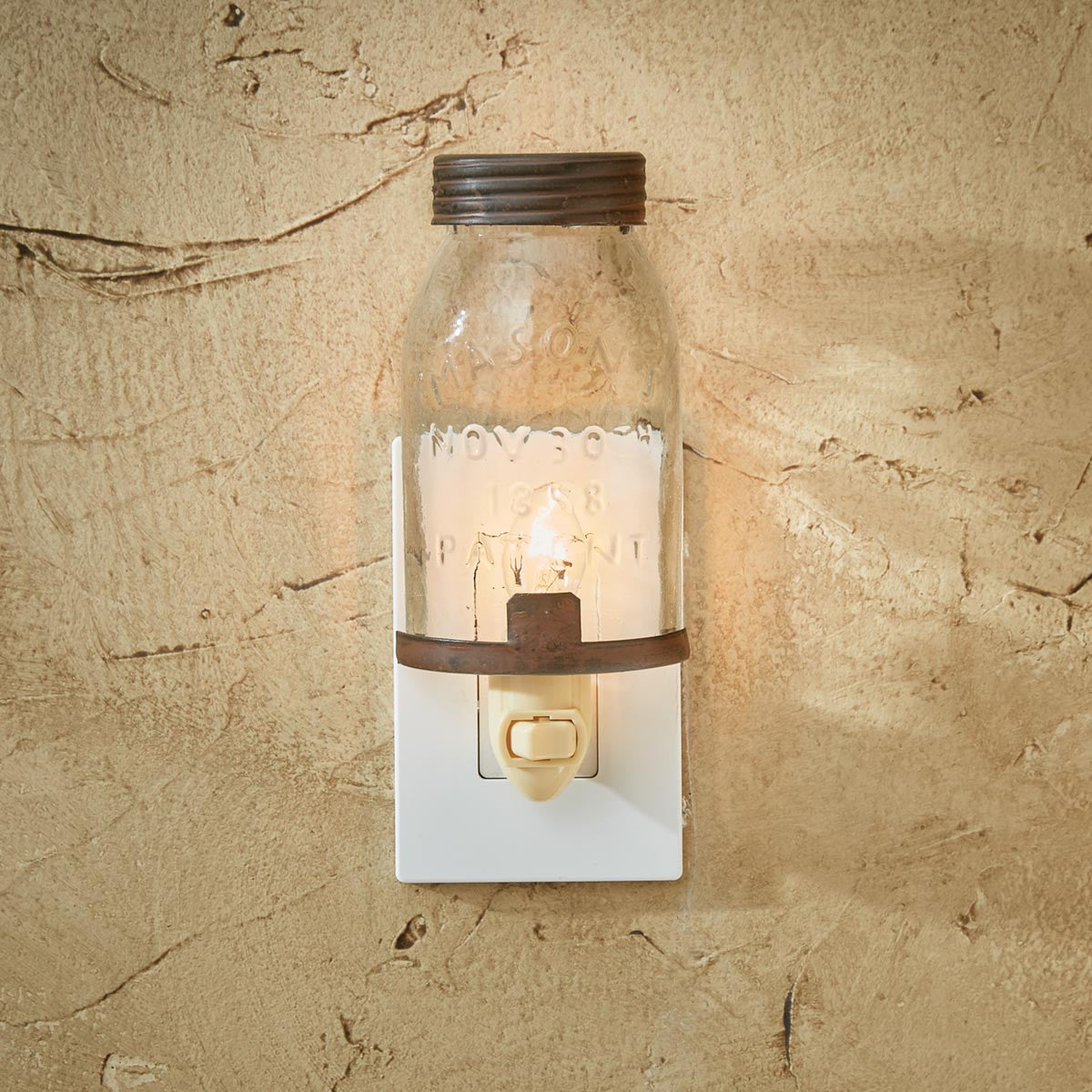 A mason jar night light plugged into a wall outlet