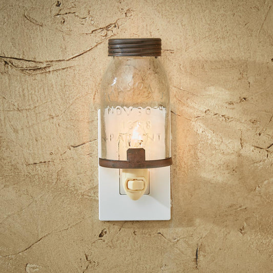 A mason jar night light plugged into a wall outlet