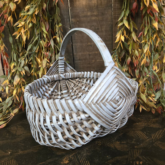 Woven basket on a wooden surface with green leaves