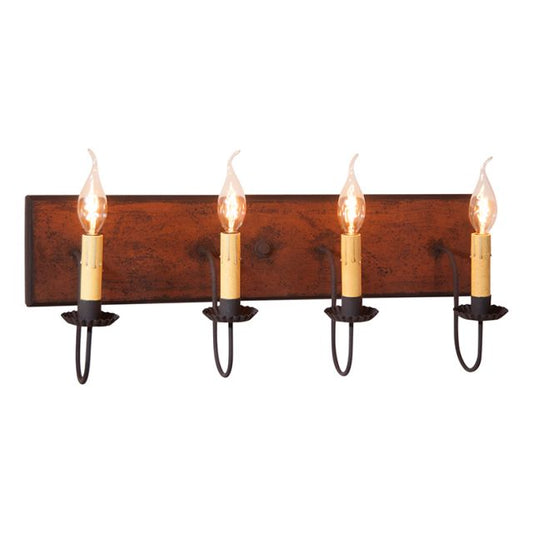 A four-light vanity light fixture with a rustic wooden backplate and black textured arms, featuring E12/Candelabra sockets.