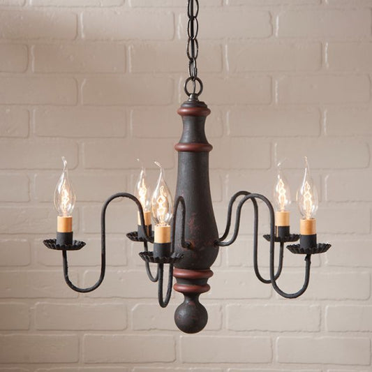 Decorative chandelier with five light bulbs against a brick wall background