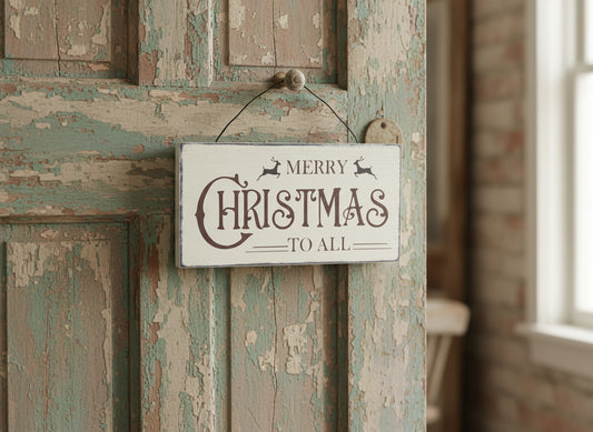Vintage-style 'Merry Christmas to All' sign hanging on a rustic wooden door.