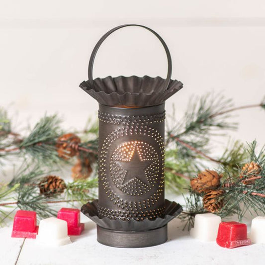 Decorative lantern with star design on a snowy background with pine branches and candles.