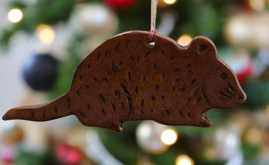 Mouse redware ornament hanging from a Christmas tree