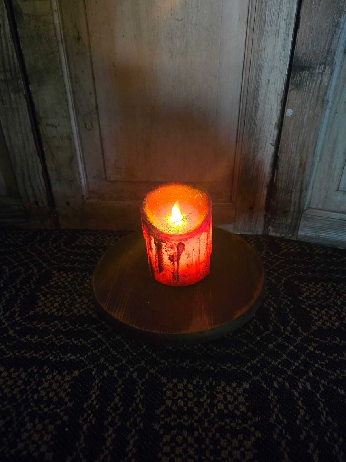 Glowing battery operated candle in a dimly lit setting.