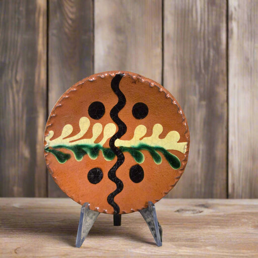 Small round slipware plate with black, green and yellow tones