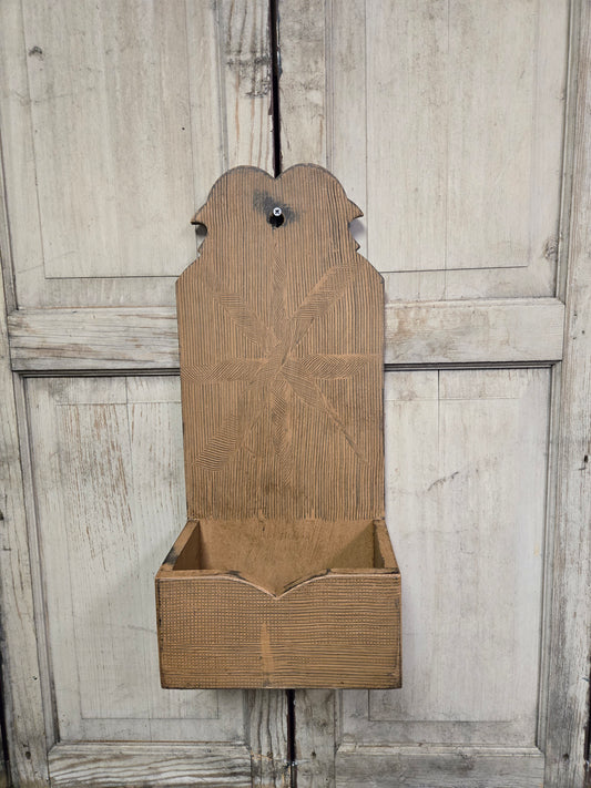 Wooden wall-mounted planter with decorative backrest against a wooden panel background