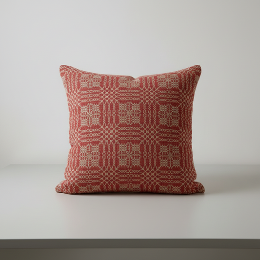 Red patterned pillow on a white surface with a light gray background