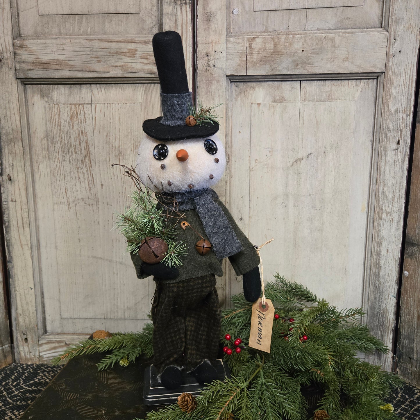 Decorative snowman with a wreath on a wooden door