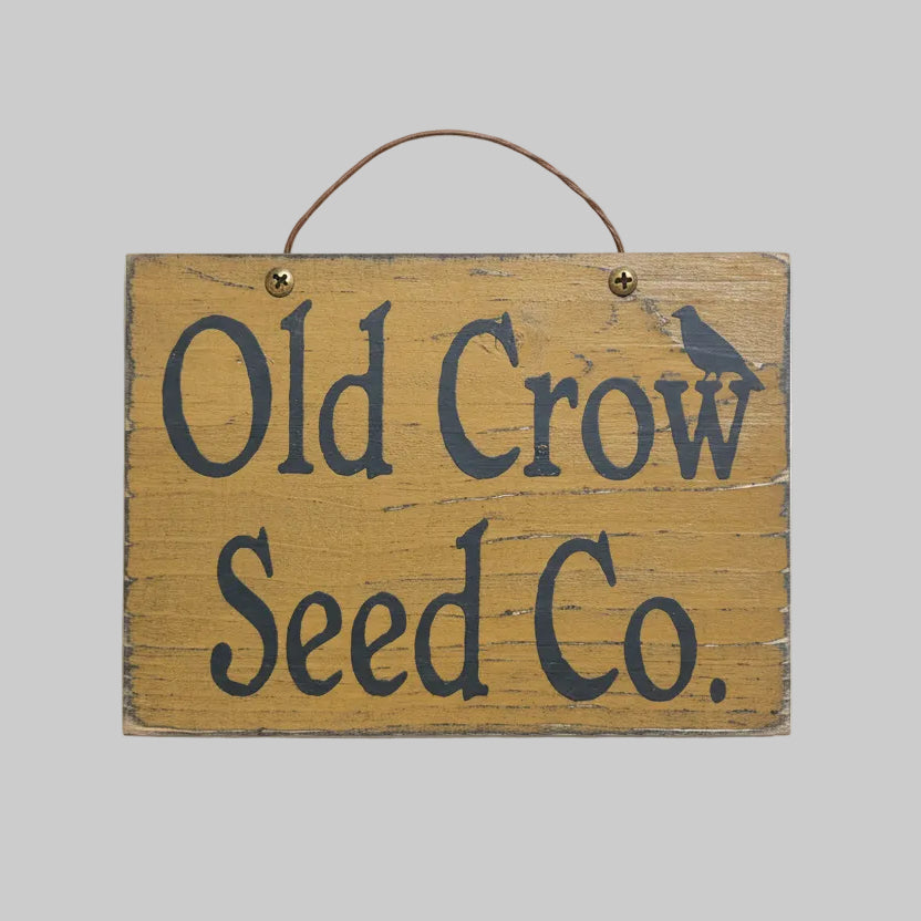 Wooden sign with 'Old Crow Seed Co.' text on a wooden background