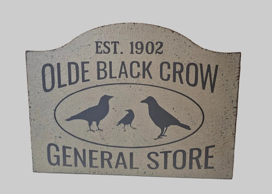 Decorative sign for Olde Black Crow General Store with birds and establishment year on a light background