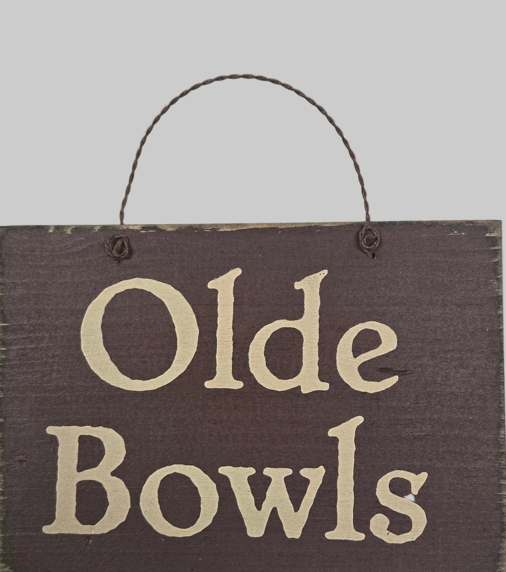 Wooden sign with 'Olde Bowls' text on a white background