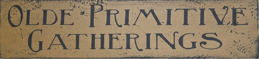 Wooden sign with 'Olde Primitive Gatherings' text on a rustic background