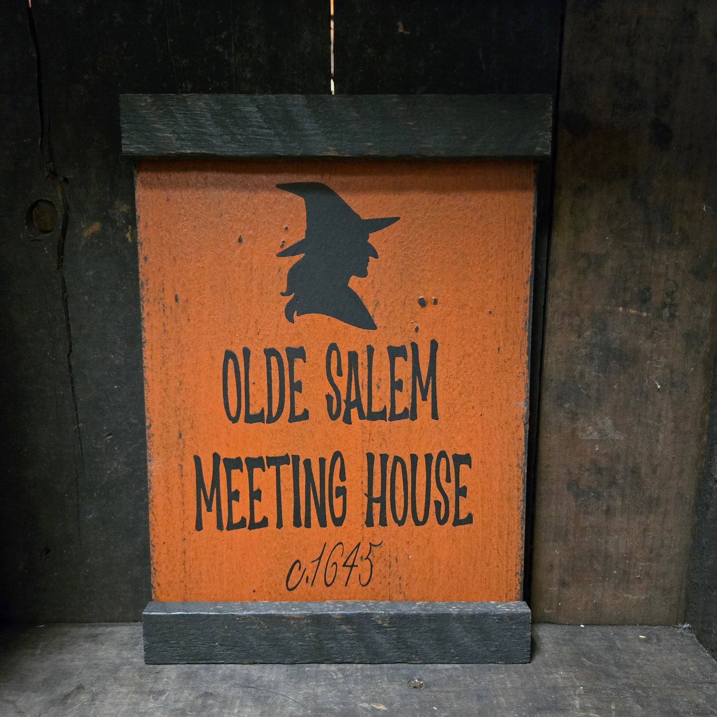 Sign with 'Olde Salem Meeting House' text and a silhouette of a witch on a broomstick.