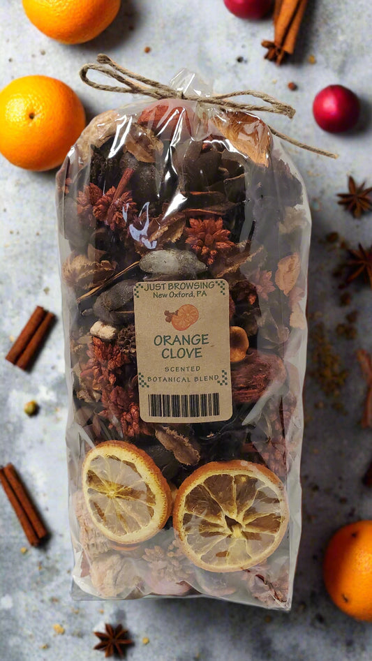 Packaged orange clove scented bundle with cinnamon sticks and oranges on a textured surface.