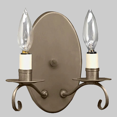 Bronze wall sconce with two candle-style light bulbs on a gray background