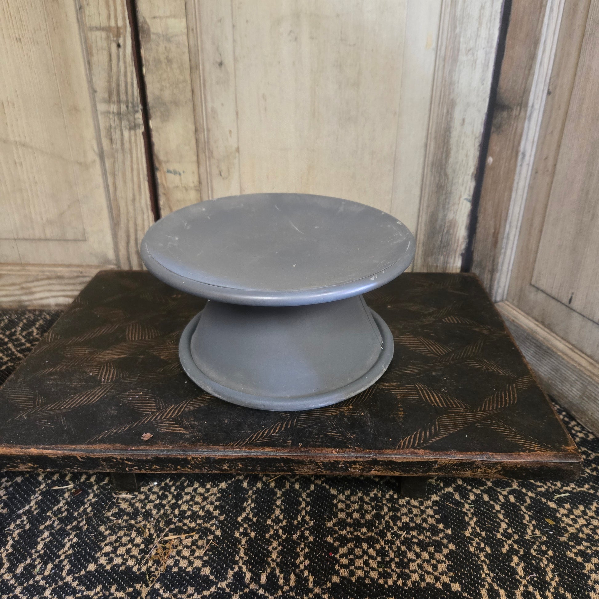 Two gray bowls on a wooden surface with a textured background