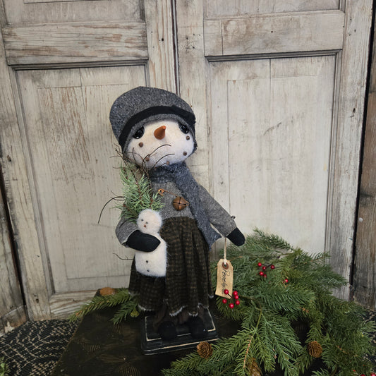 Decorative snowman figure with a tag on a wooden door