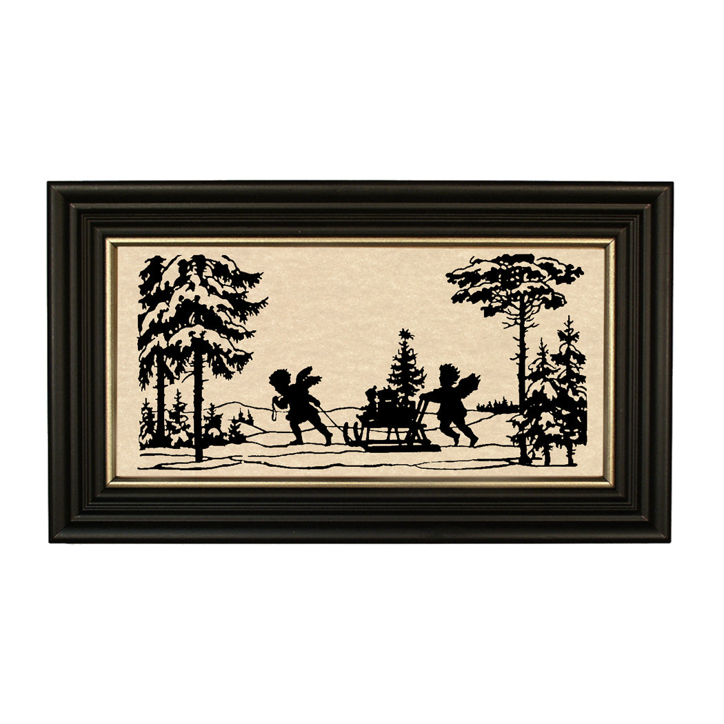 A framed black cut-paper silhouette of two figures with a Christmas tree and sleigh in the background, set against an aged paper surface.