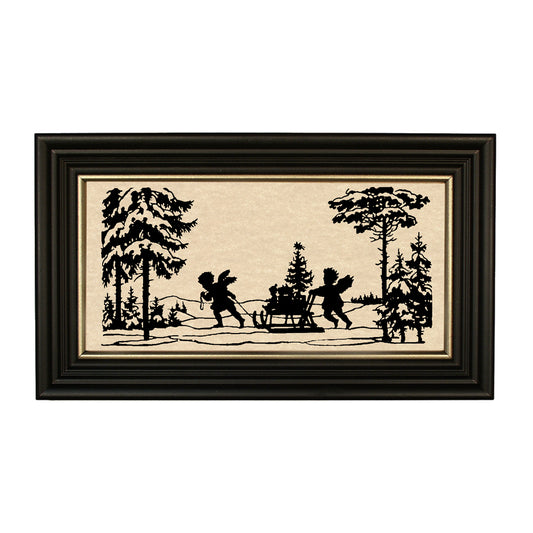 A framed black cut-paper silhouette of two figures with a Christmas tree and sleigh in the background, set against an aged paper surface.
