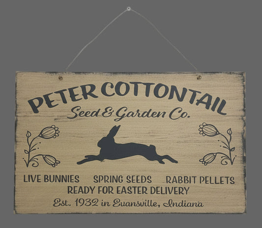 Wooden sign with 'Peter Cottontail Seed & Garden Co.' text and rabbit silhouette on a mustard background