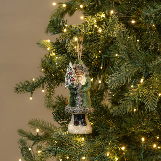 Christmas tree ornament of a Santa Claus figure with a tree on a lit Christmas tree.