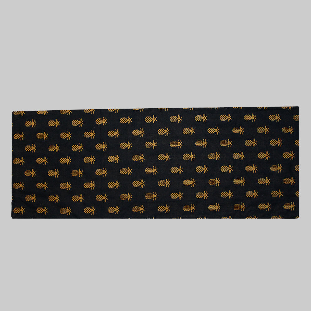 Black table runner with a geometric pineapple pattern woven in gold color.