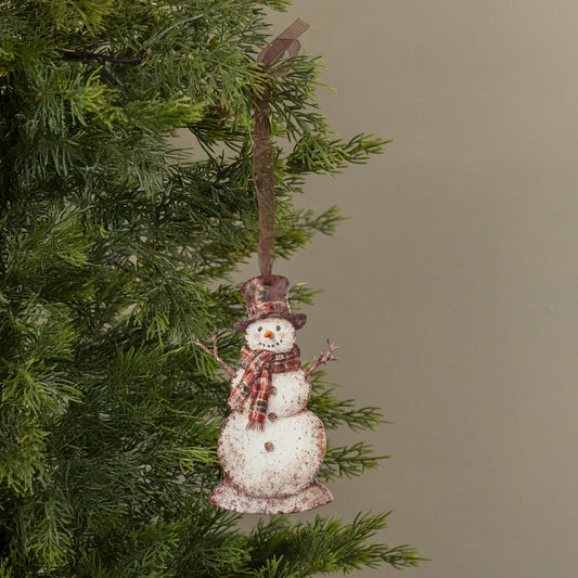 Snowman ornament hanging on a Christmas tree with a plain background