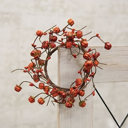Decorative wreath with red berries on a neutral background