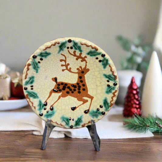 Small round redware plate with a prancing stag and holly border 