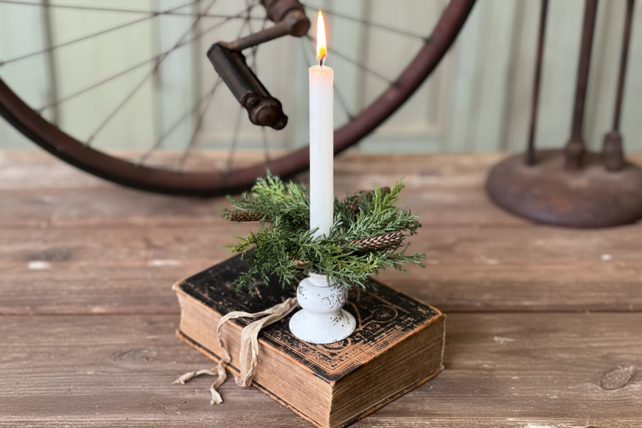 Decorative candle holder with greenery on an old book, rustic background
