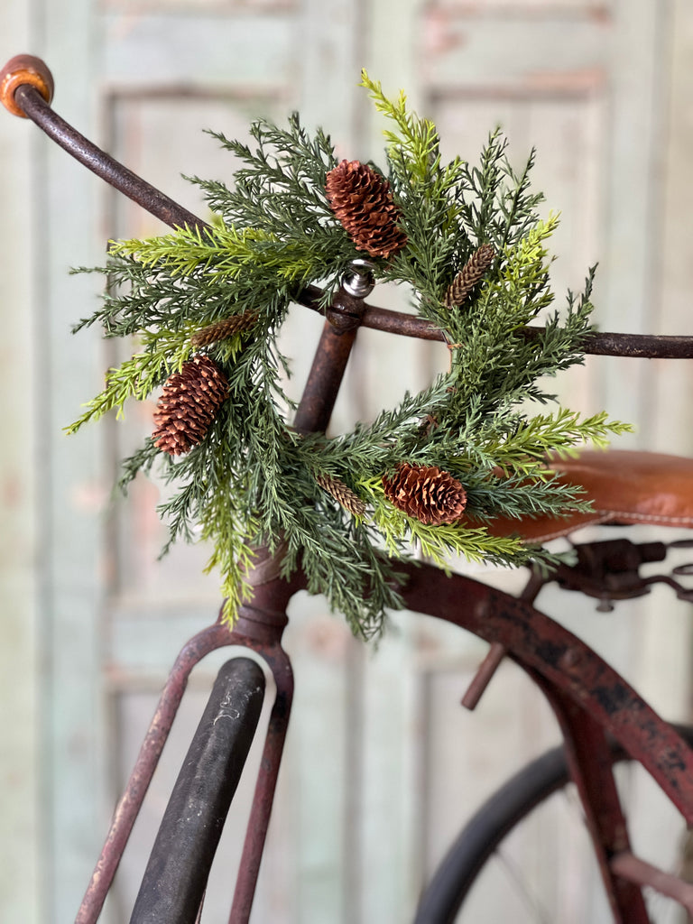 Prickly pine candle ring hanging on bicycle handle bar.