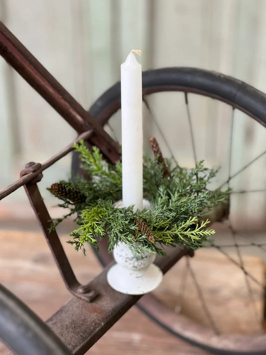Candle ring in a decorative holder with greenery on an old bicycle