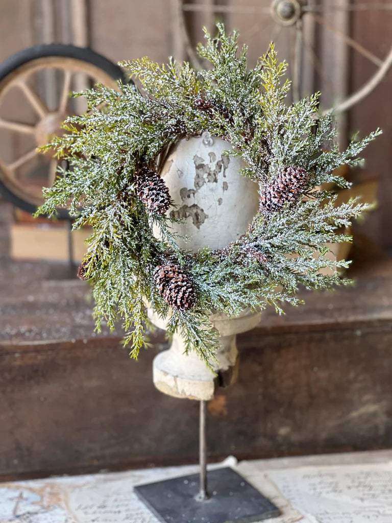 Candle ring hanging from wood spool.