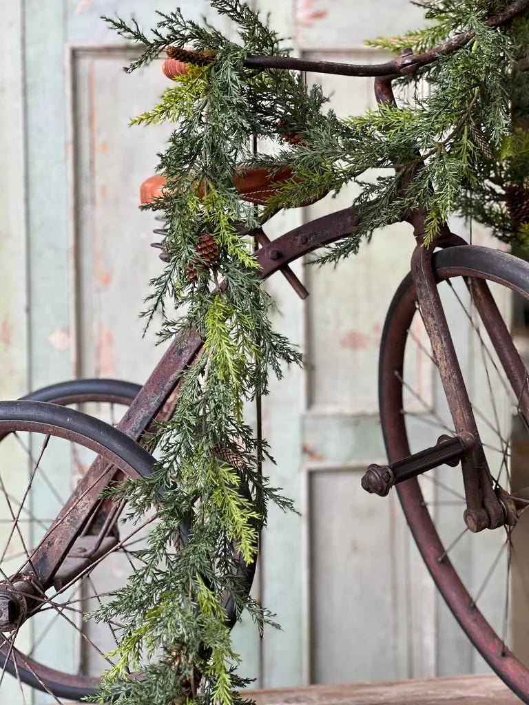 Pine garland on an antique bicycle.