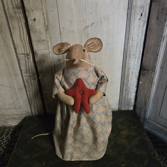 Decorative mouse figure with a star on a wooden surface