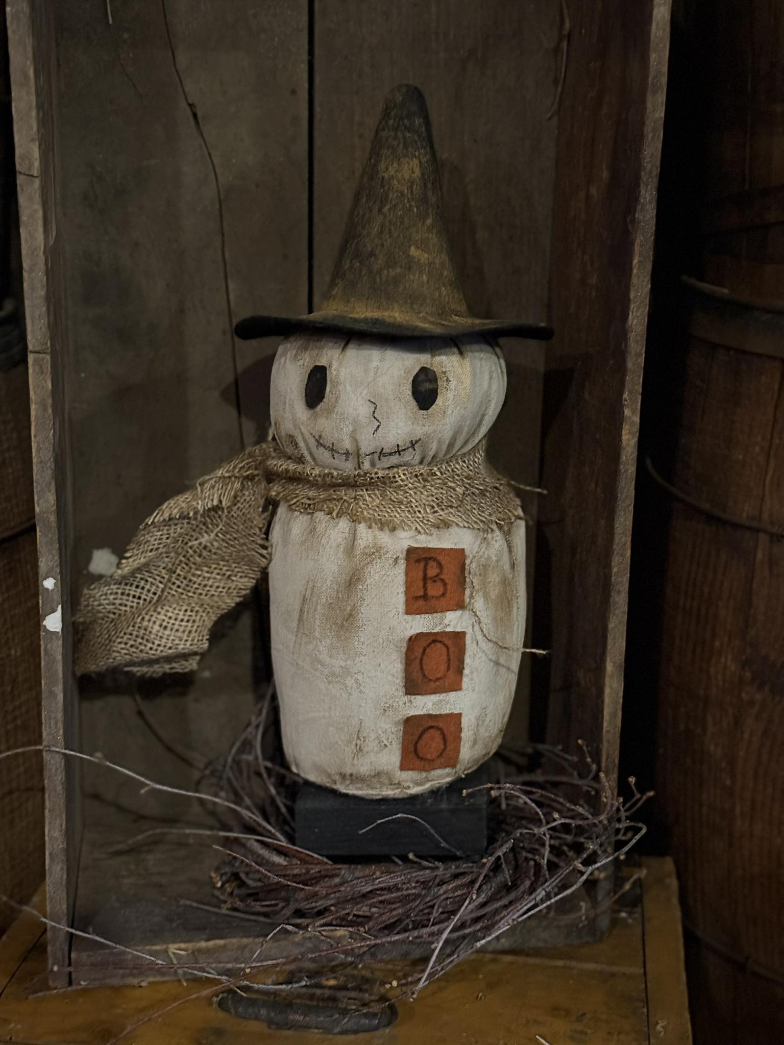 Scarecrow figure with a hat and wooden blocks in a rustic setting